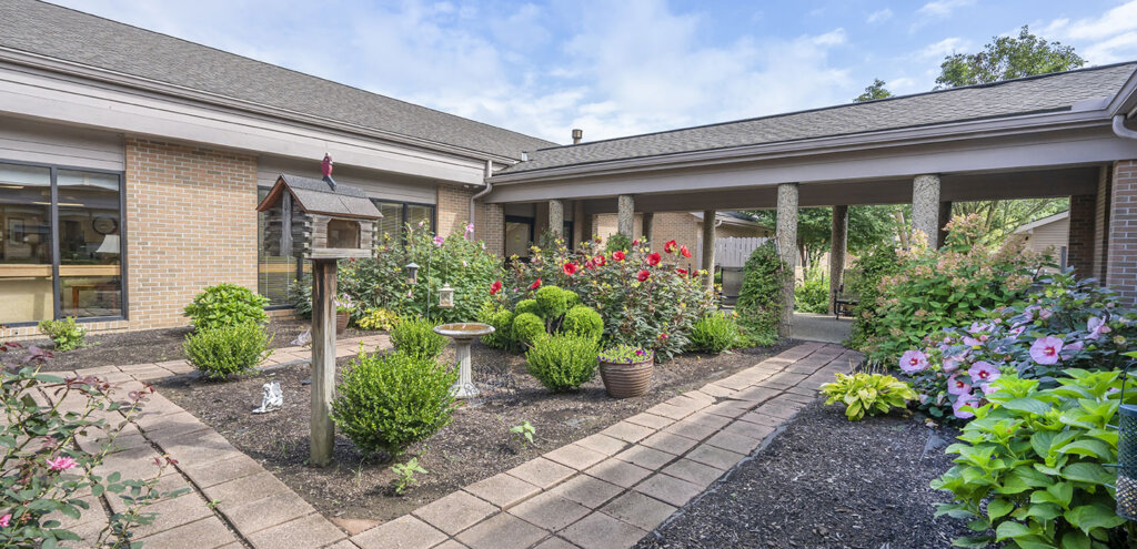 Landscaped garden courtyard at Traditions of Mount Vernon with walking path and covered walkway